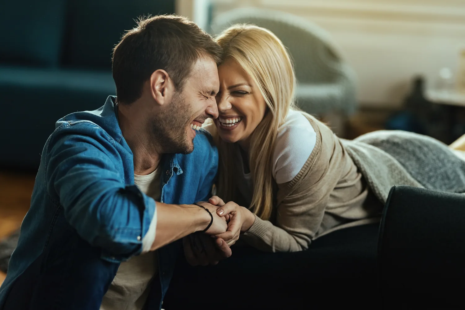 Couple sharing a conversation on a sofa, preparing questions about HSV testing without making assumptions