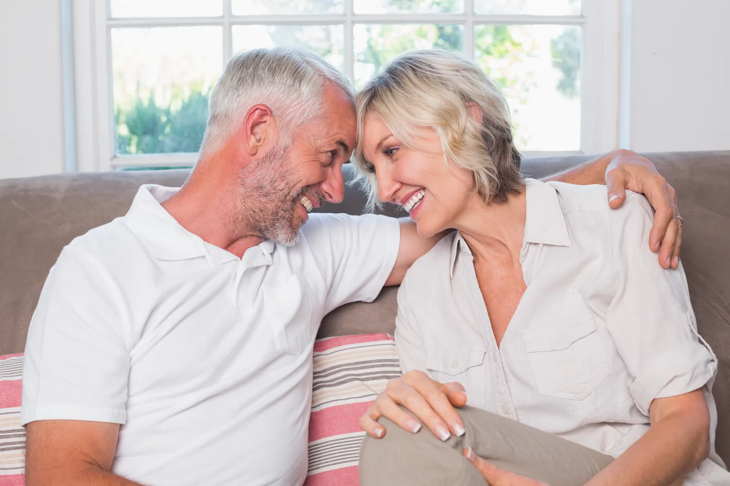Mature adults leaning together on a sofa, illustrating closeness while partners make informed HSV decisions